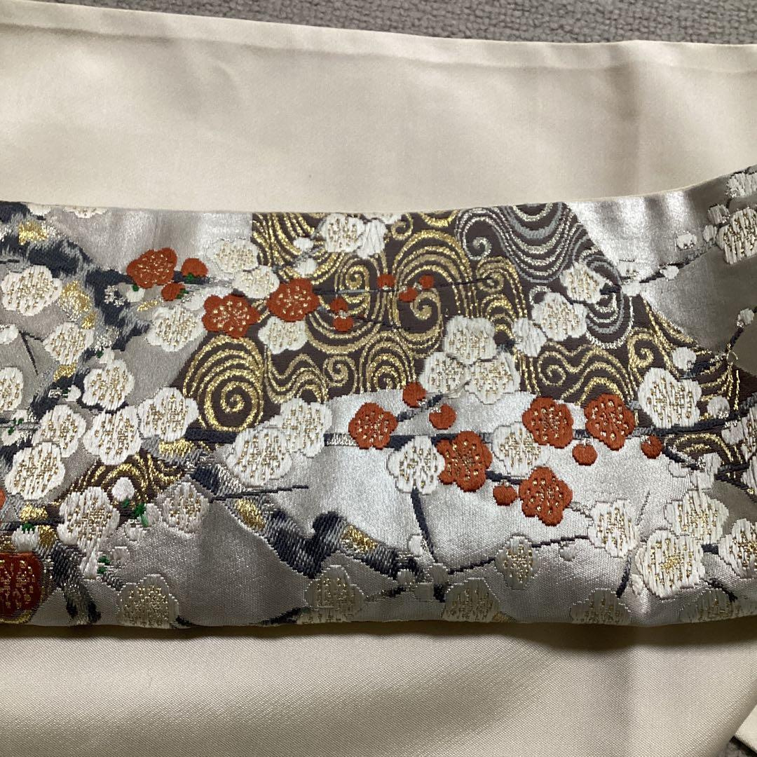 高級袋帯　唐織　シルバーの正絹の生地に刺繍のような浮き上がった紅白の梅　逸品