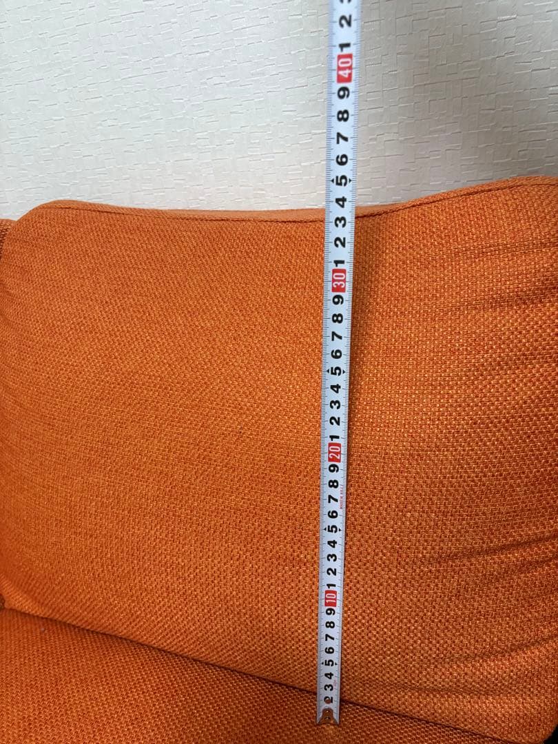 オレンジ色の3人掛けソファ