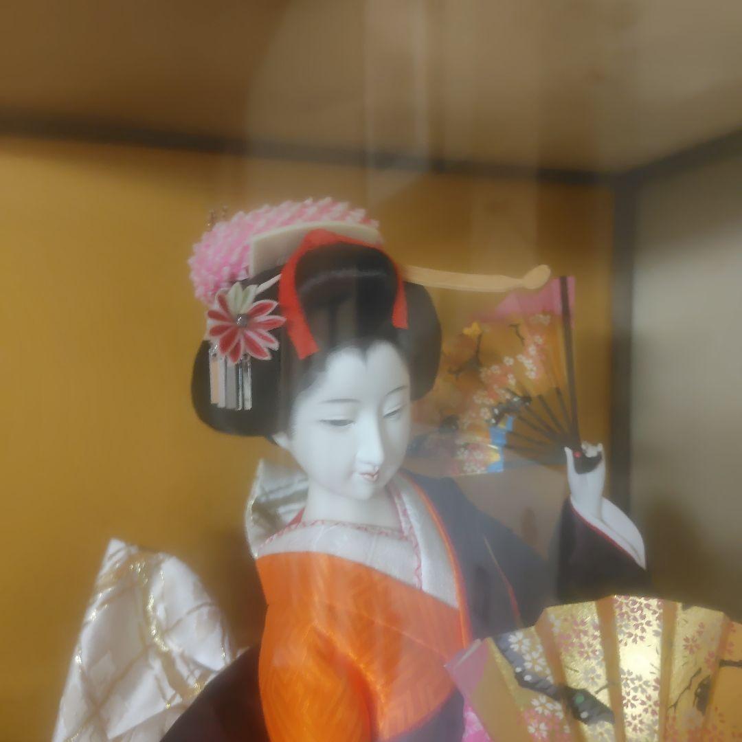 御所人形 オレンジと黒の衣装 ガラスケース入り