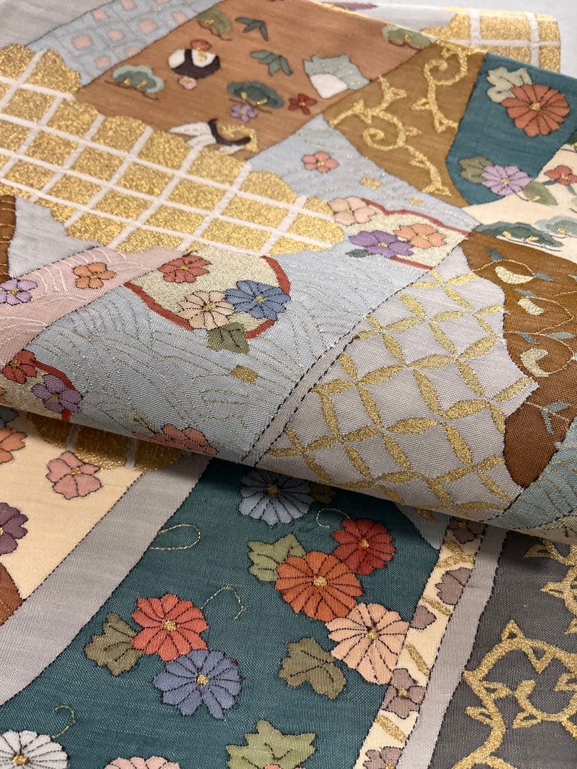 仕立て上がり新品袋帯　薄いグレーに鶴松花宝尽くしなどおめでたい柄　とても可愛い